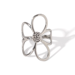 Close-up of polished stainless steel ring with hollow flower design and textured center