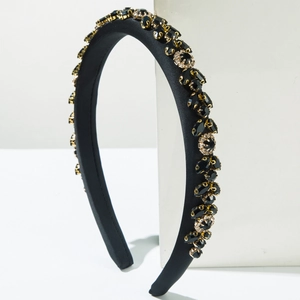 Close-up of black sponge headband with sparkling rhinestones and golden claw settings