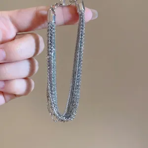 Multi-layer silver bead chain bracelet with a modern tassel design and metal clasp