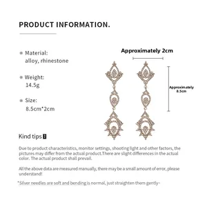 Détail de longues boucles d'oreilles goutte d'eau avec strass et alliage poli