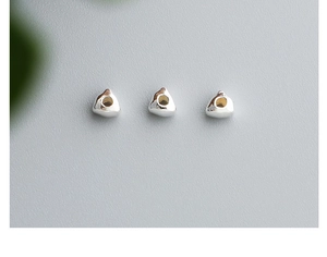 Macro shot of three S925 sterling silver geometric triangle beads for DIY jewelry making