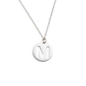 Gros plan d'un collier en acier inoxydable argenté avec pendentif rond gravé de la lettre M