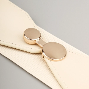 Close-up of beige elastic waist belt with premium golden circular buckle detail