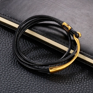 Close-up of a double-wrap black leather bracelet with a polished gold magnetic clasp