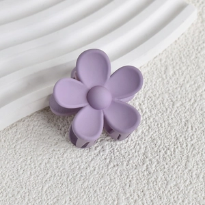 Detail of a matte light purple flower hair claw clip on a clean white display surface