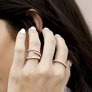 Close-up of sparkling silver rings and a serpent band on a model finger