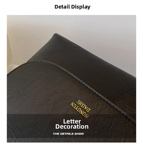 Close-up of black lychee grain leather with gold lettering detail on the chain bag