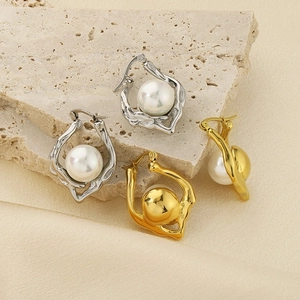 Artistic detail of irregular hammered 18k gold and silver earrings with white pearls