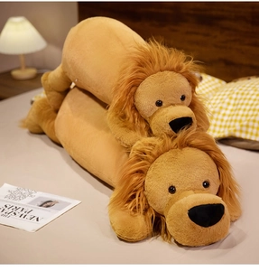 Detail of plush lion bolster pillows in large and small sizes on a cozy warm bed