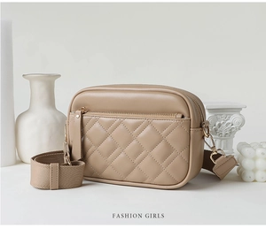 Detail of khaki quilted crossbody bag with golden zipper and stylish wide strap