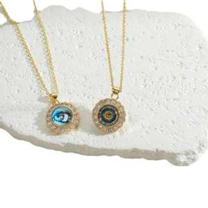 Golden necklace with round evil eye pendant and zircon micro-inlay on white stone