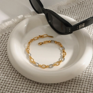 Bracciale bicolore in oro 18k e argento in acciaio inossidabile su piatto di ceramica