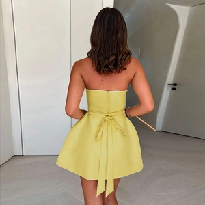 Détail du grand nœud papillon au dos d'une robe courte jaune sans bretelles