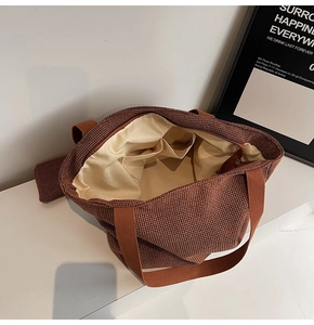 Close-up of woven tote bag interior featuring satin lining and double slip pockets