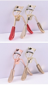 Detail showing assorted metal eyelash curlers in red, gold, and rose gold finishes