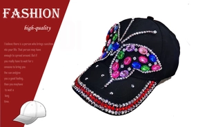 Close-up of colorful rhinestone butterfly design on a black denim baseball cap