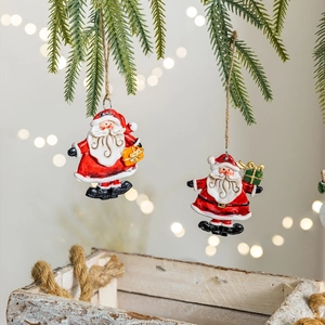 Vintage resin Santa Claus hanging ornaments on pine branches with warm festive lighting