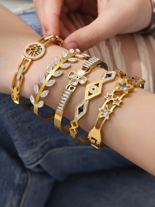 Detailed view of 18k gold plated bracelet set with heart, clover, and zircon inlay