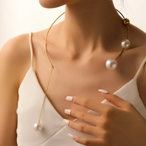 Exaggerated gold choker necklace with white pearl tassels and open-ended metal frame