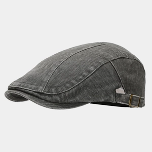 Close-up of charcoal grey washed denim beret featuring adjustable bronze metal buckle