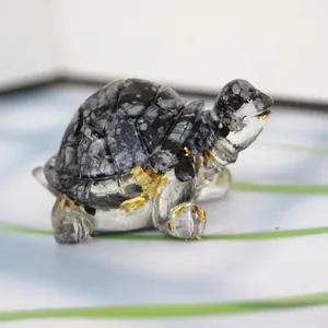 Detailed view of turtle figurine made of white spotted stone with gold foil accents
