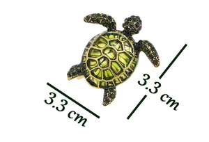Detail shot of vintage sea turtle brooch with green enamel shell and inlaid rhinestones