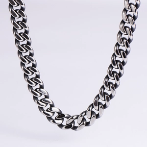 Macro shot of polished stainless steel cuban curb chain links with heavy industrial texture