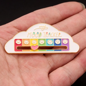 Macro view of cloud mood tracker pin with rainbow slider and movable pink heart detail