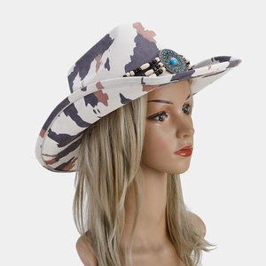 Detail of cow-print western hat featuring turquoise bead band and wide brim design