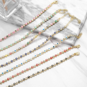 Detail of colorful Evil Eye charm bracelets with gold-plated chains and zircon stones