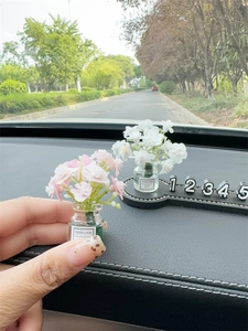 Macro shot of miniature artificial flowers in glass bottles for car dashboard decoration