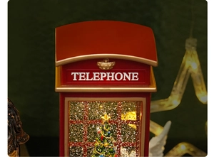 Close-up of red Christmas telephone booth music box with sparkling tree and LED lights