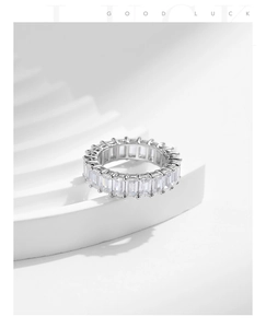 Macro shot of silver eternity band featuring baguette-cut sparkling cubic zirconia
