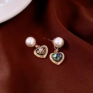 Boucles d'oreilles vintage avec perles et nacre sur fond de satin de soie sombre