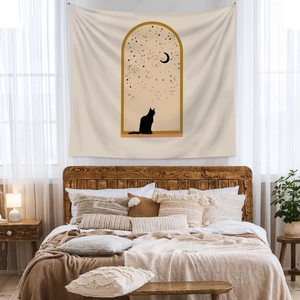 Detail of minimalist Bohemian tapestry with black cat and moon design on a bedroom wall