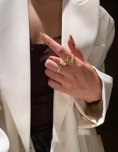 Close-up of gold plated crisscross ring set with cubic zirconia stones on model