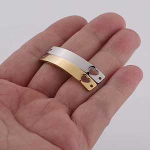 Close-up of curved gold and silver steel bars with heart cutout on a hand for scale