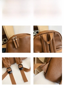 Detail view of smooth metal zippers and reinforced shoulder straps on brown leather backpack