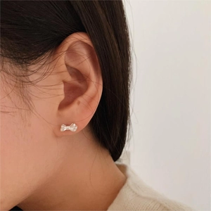925 sterling silver bow stud earrings with 3D texture on model for a minimalist look