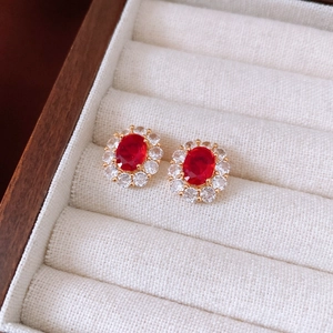 Macro shot of 18K gold plated oval red gemstone earrings with clear crystal halo