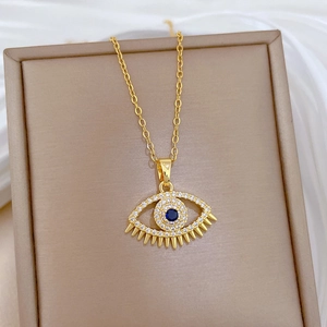 Close-up of gold Evil Eye necklace with blue gemstone and cubic zirconia in box