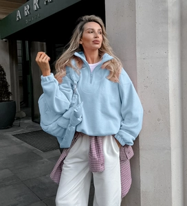 Detail of light blue fleece half-zip sweatshirt fabric and standing collar design