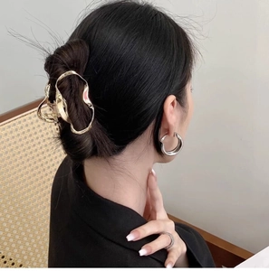 Detailed side view of a gold liquid cloud metal hair claw clip in an elegant hairstyle