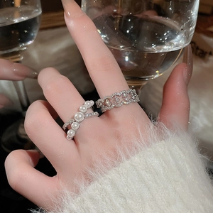 Detail of French pearl cross ring with pavé zircons worn on hand in a luxury setting