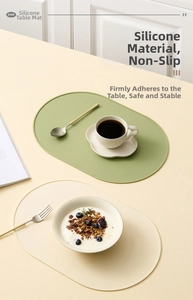 Nahaufnahme von hitzebeständigen Silikon-Tischsets in Grün und Beige auf einem Holztisch