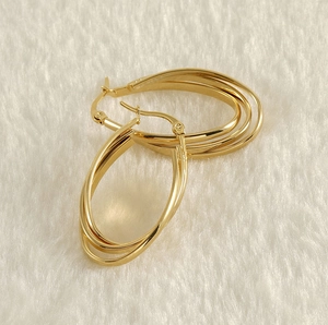 Macro shot of 18k gold plated triple-layered oval hoop earrings with a glossy finish