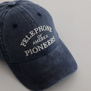 Navy blue washed baseball cap with white vintage embroidery and distressed texture