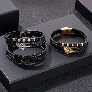 Detail of multi-layer leather bracelet with stainless steel feather charm and secure clasp