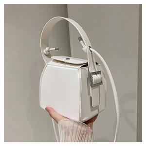 Detail of white PU box bag featuring a knotted handle and geometric structured design