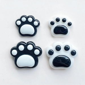 Detailed view of resin cat paw charms in black and white colors for DIY phone cases